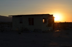 sunset behind a crumbling desert home